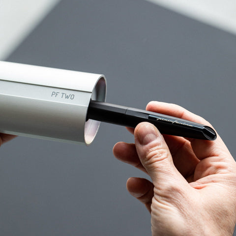 Hand taking the Pininfarina Segno "PF TWO" in its black ballpoint pen version out of its packaging.