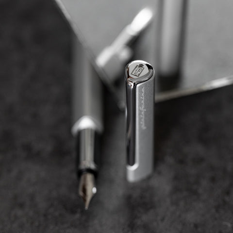 Close up of the cap of the Pininfarina Segno "PF ONE Fountain Pen" in its silver version. The cap has the Pininfarina logo in the tip.