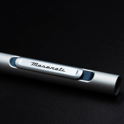 Close up of the Pininfarina Segno "Slider Maserati Edition" ballpoint pen with aluminum body and blue details with the Maserati logo.