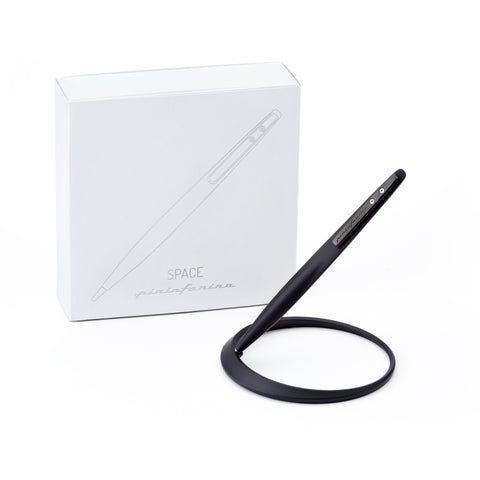 Pininfarina Segno "Space" ethergraf inkless pen with magnesium body in its black version standing in its ellipsoidal aluminum desk base next to its packaging box.