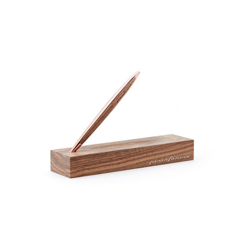 Pininfarina Segno "Cambiano Luxury" Ethergraf Inkless pen with rose gold plated stem and walnut wood inserts standing in its walnut wood base in white background.
