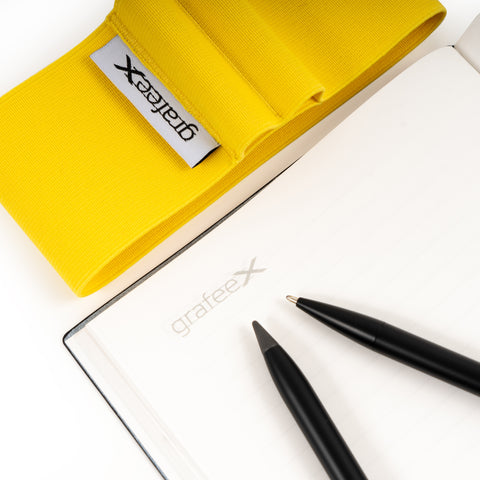 Close up of the Grafeex, which includes the Pininfarina Grafeex ballpoint and pencil, the Pininfarina Notebook Stone Paper, and its elastic band