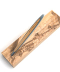 Closeup of the Pininfarina Segno "Cambiano Italian Beauty" Ethergraf Inkless or ballpoint pen with silver aluminum body and walnut wood inserts standing in its base with plans of different cities in Italy in a white background.