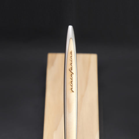 Close up of the Pininfarina Segno logo in the "Cambiano Classic" Ethergraf Inkless pen with aluminum body and cedar wood inserts and base.