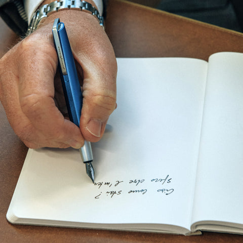 Hand writing with the Pininfarina Segno "PF GO Fountain Pen" in its blue version.