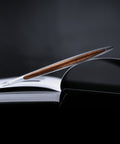 Pininfarina Segno "Cambiano Classic" Ethergraf Inkless pen with aluminum body and walnut wood inserts in a open notebook.