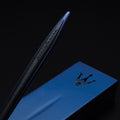 Close up of the Pininfarina Segno "Cambiano Ink Blu Maserati Edition" ballpoint pen with blue aluminum body and black rubber inserts laying in its blue base with the maserati logo in a black background.