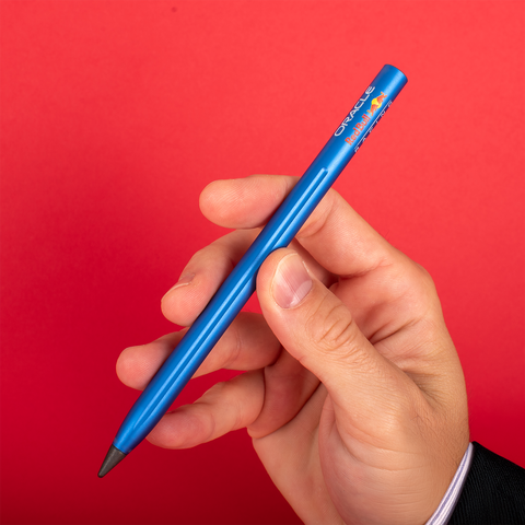 Hand holding the Pininfarina Segno "SMART Oracle Red Bull Racing Edition" pencil with grafeex tip and blue painted aluminum body with the Oracle Red Bull Racing logo.