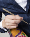 Man holding the FO - Forever Made In Italy "Prima" Ethergraf inkless pen with anodized aluminum long body in the color Gold.