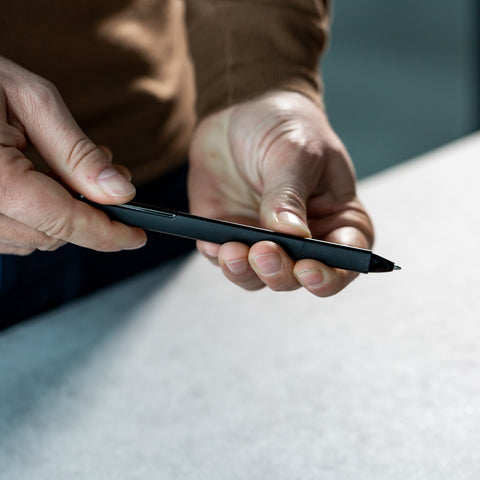 Hands of a man holding the Pininfarina Segno "PF ONE Ballpoint" pen in its black version.