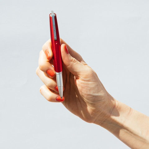 Hand holding the Pininfarina Segno "PF GO Rollerball" pen in its red version.