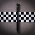 Pininfarina Segno "SMART Maserati Edition" pencil with grafeex tip and black painted aluminum body with a yellow Maserati trident in a checkered flag and concrete background.