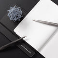 Pininfarina Speedform Transitions collections in its Titanium and silver versions on a desk with the Pininfarina Notebook Stone Paper